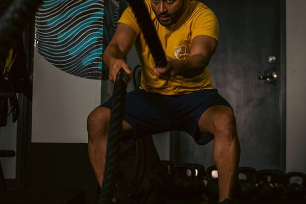 Man performing strength exercises in a dark gym setting